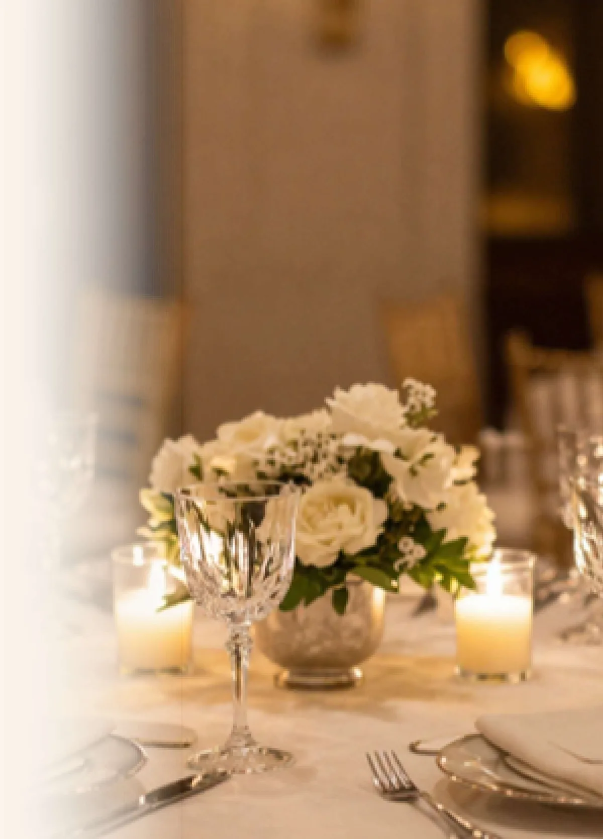 Candlelit wedding reception table with white roses styled by PlanItBetter
